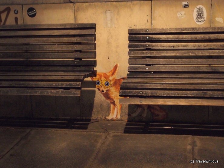 Depiction of a cute fox hidden behind benches in Vienna, Austria